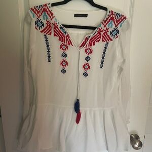 White blouse with embroidered red, aqua and navy design.